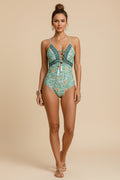 Woman wearing a green floral one-piece swimsuit with jewelry.
