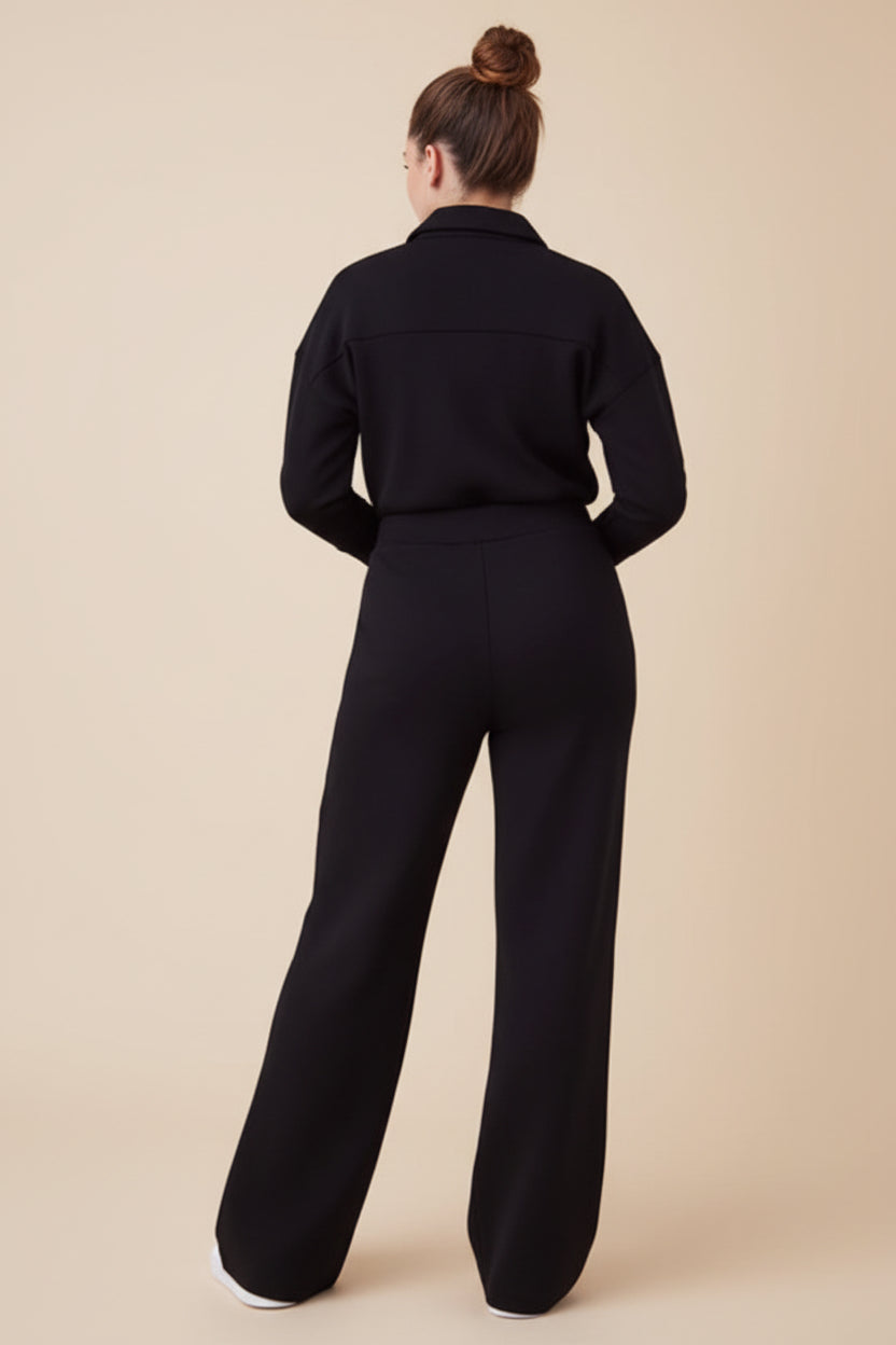 Person wearing a black jumpsuit on a white background