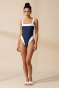 One-piece swimsuit with white top and navy bottom on a gray background