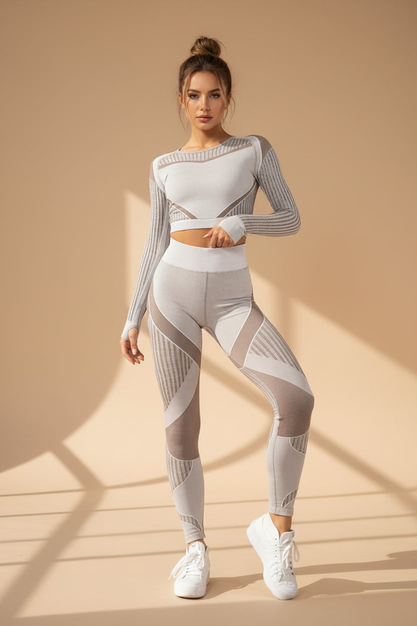 Woman wearing a gray and white athletic outfit on a white background