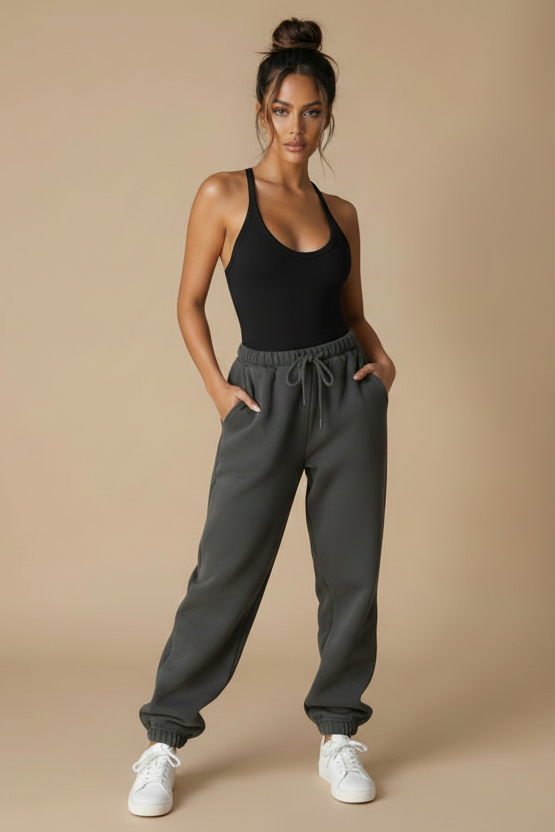 Woman wearing a beige bodysuit and gray sweatshirt against a white background
